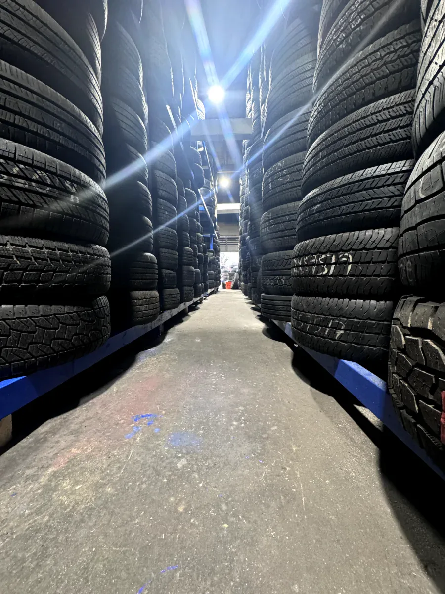 Tire warehouse at Edwin Tire Shop in Brentwood MD Warehouse aisle stacked high with used tires at Edwin Tire Shop