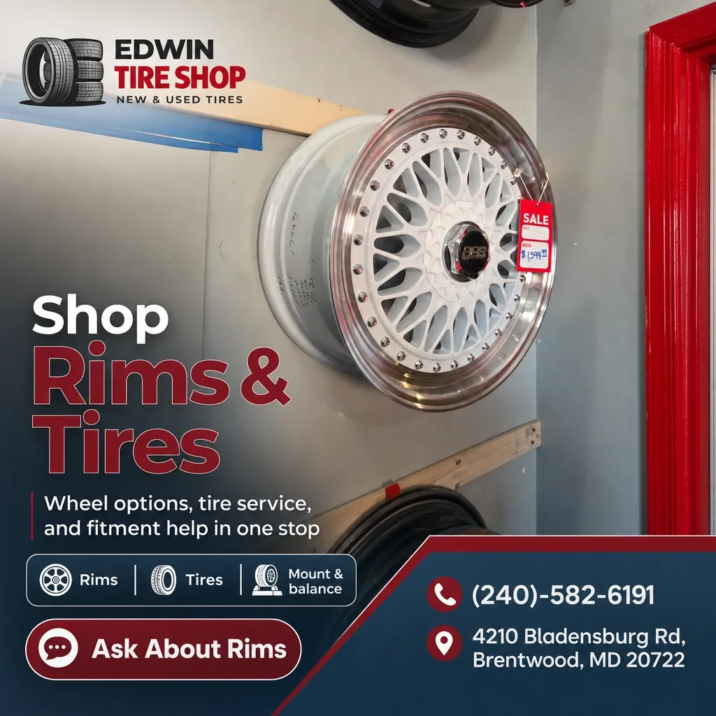 Wall-mounted white multi-spoke rim on display inside Edwin Tire Shop with service and contact info graphics